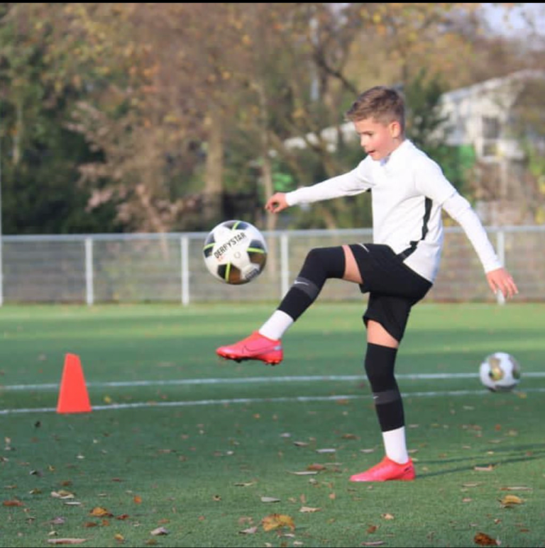 Jeugdspeler van DPC Academy neemt een schot tijdens een buitentraining.