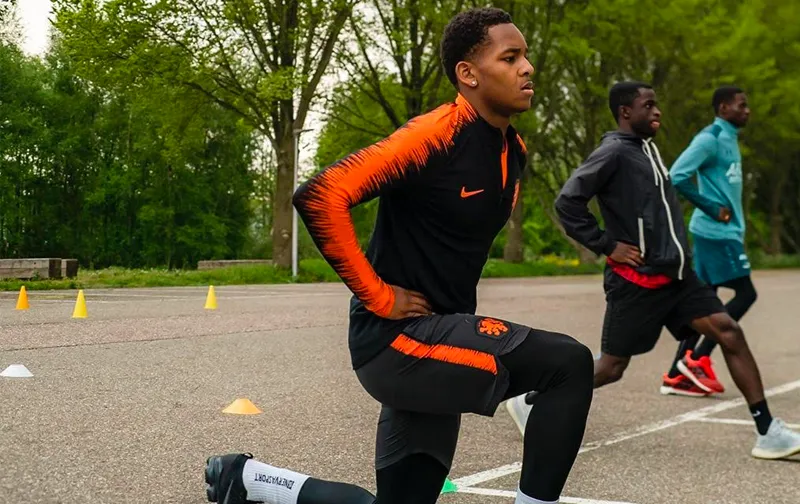 Spelers van DPC Academy tijdens een warming-up oefening buiten.